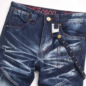 Gedetailleerd overzicht retro gewassen denim jeans voor heren, rode stiksels en metalen klinknagels.