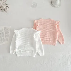 Detailed view of cute baby girls knit cardigan sweaters with delicate shoulder ruffles.