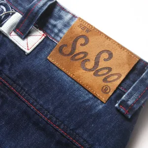 Detailopname van de lederen patch in de taille van blauwe herenjeans met stiksels.