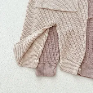 Detalle de mameluco de punto para bebé con diseño liso y prácticos botones de presión.