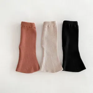 Close-up detail of knitted baby flare leggings in three colors, soft texture for infants.