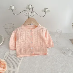 Vista dettagliata del cardigan in maglia rosa da neonato, morbido cotone per bimbi.