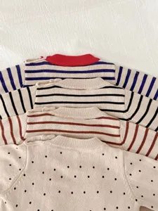 Baby gebreide trui detailopname met schattige gestreepte en gestippelde patronen voor baby's.