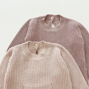 Vista detallada de jersey de punto para bebe, parte superior de manga larga lisa.