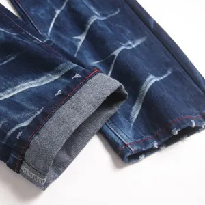 Heren stretch slim fit denim jeans detailweergave met uniek wassing patroon en rode stiksels.
