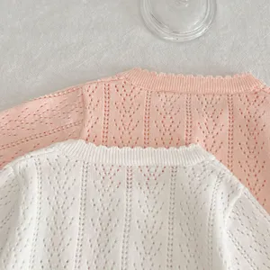 Dettaglio cardigan in maglia di cotone per bambina con trama traforata dolce e tessuto traspirante.