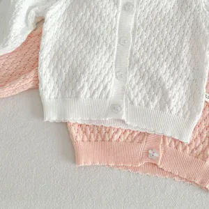 Girls knitted cardigan sweater detailed view showing soft fabric texture and cute flower buttons.