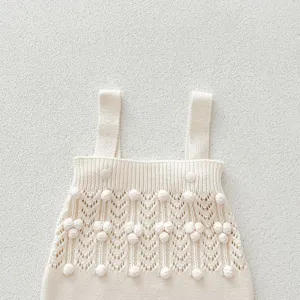 Knit baby romper detail shot, cute hollow out pattern with handmade balls, soft woolen fabric.