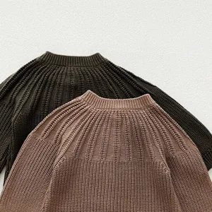 Detailed view of infant knitted sweater texture, crew neck and long sleeves design, close-up.