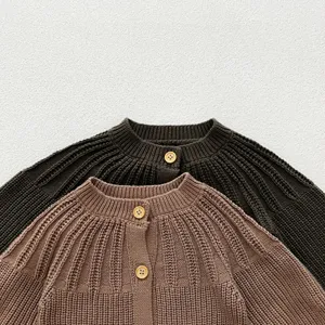 Detail shot of baby knitted cardigan, soft cotton yarn material with cute wooden buttons.