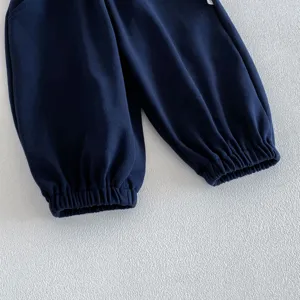 Nahaufnahme der dunkelblauen Kinderhose mit elastischen Bündchen und feiner Textur.