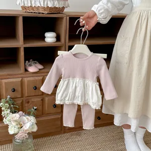 Détail ensemble vêtements bébé fille rose côtelé, haut à bordure dentelle et leggings.