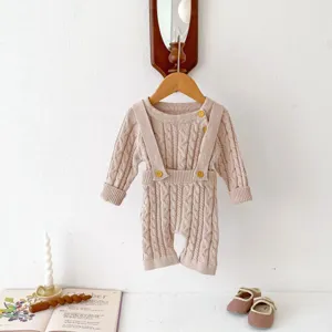 Infant knitted cable-knit romper set detail view, beige baby overalls with cute buttons.