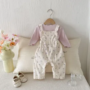 Detailansicht des Herbst-Baby-Mädchen-Sets mit geblümter Latzhose und lila Langarmshirt.