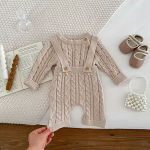 Infant baby cable knit romper jumpsuit with cute straps and buttons in beige color.