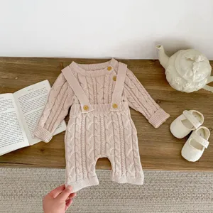 Close-up detail of cable knit baby romper set featuring soft texture and wooden buttons.