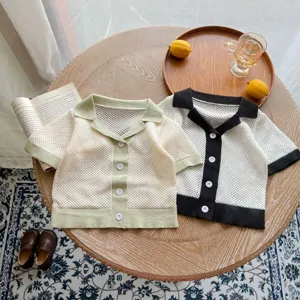 Detailed view of baby knitted hollow short-sleeve cardigan with lapel and button closure design.