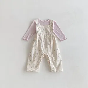 Detailansicht des niedlichen Baby Mädchen Blumen Latzhose und Langarmshirt Set Baumwolle.