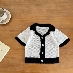Detailed view of baby knit cardigan, black and white color block, hollow out design.