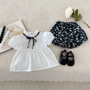 Nahaufnahmen des süßen Sommersets für Mädchen mit Bluse und Shorts sowie Schuhen.