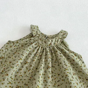 Gros plan détaillé de l'encolure du haut bébé vert à fleurs montrant les fines fronces.