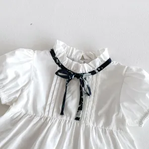 Süße Kleinkind Mädchen weiße Kurzarm Bluse mit Blumenband Rüschenkragen und Puffärmeln.
