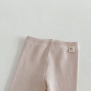 Gros plan détail de leggings côtelés rose clair pour bébé fille, taille élastique douce.