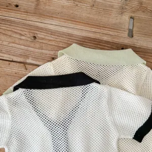 Detailed view of infant knit cardigan, hollow mesh knit fabric, contrast collar and cuffs.
