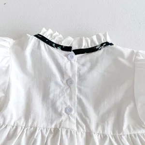 Detailansicht der weißen Kleinkindermädchen Bluse hinten mit Rüschen und Knöpfen.