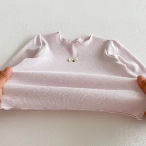 Rosa Langarm Baumwoll-Oberteil fuer Babys mit Schleife und elastischem Feinstrick-Stoff.