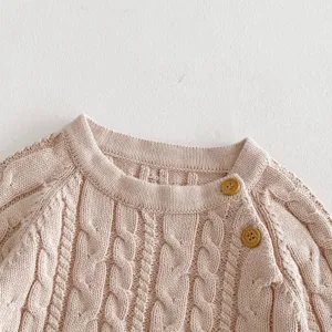 Infant knit sweater detail shot, cozy cable knit pattern, soft pink baby pullover apparel.