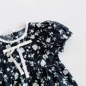 Nahaufnahme einer Kleinkind Mädchen Blumenbluse mit weißem Kragen und süßer Schleife.