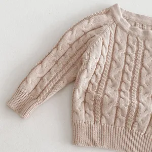 Close up detail of baby cable knit sweater, soft round neck pullover, fine fabric texture.