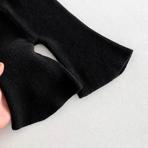 Toddler knit flare pants cuff detail, soft black cotton ribbed fabric close-up shot.