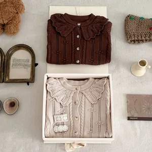 Cute infant knit cardigan with doll collar, sweet toddler baby sweater in detail view.