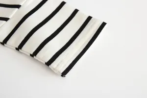 Close-up detail of black and white striped baby long sleeve t-shirt cuff, soft cotton fabric.