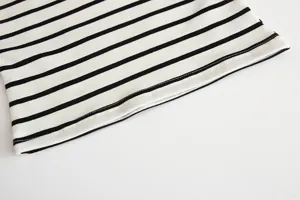 Close-up detail of infant black and white striped cotton shirt, soft fabric and neat stitching.