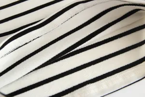 Close-up detail of black and white striped cotton fabric and stitching for baby top.