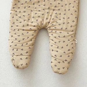 Infant baby winter warm romper detail shot, cute black cherry print corduroy fabric design.