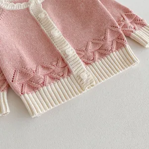 Cute baby girl pink knit cardigan detail view, soft cotton blend sweater with buttons.