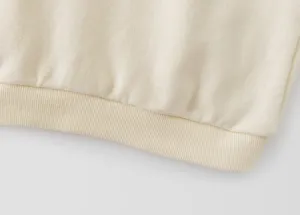 Detailed view of the kids sweatshirt ribbed hem, soft fabric texture close-up product shot.