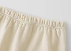 Comfortable kids apparel elastic waistband close-up, soft beige fabric detail presentation.