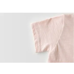 Detalle de manga de camiseta lisa para bebe, tela suave y transpirable de cerca.