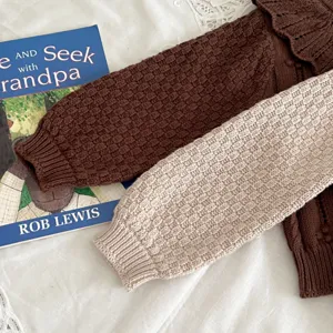Baby knit cardigan detail, cute doll collar, soft cotton yarn fabric, brown and beige colors.
