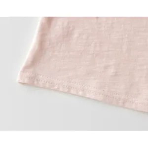 Primer plano del dobladillo de la camiseta de bebé rosa con tela suave y costuras.
