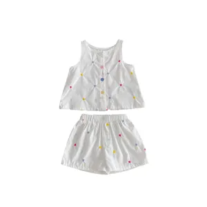 Simpatico set estivo per bambine con top smanicato con bottoni e pantaloncini ricamati.