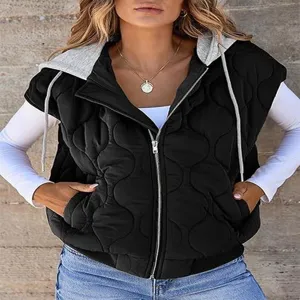 Close-up detail of women's black quilted hooded vest, sleeveless design with zipper.