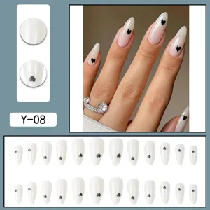 Detailed view of almond press on nails with cute black heart design, glossy finish and elegant.