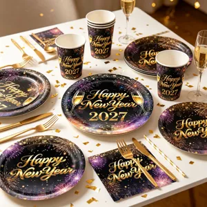 Close-up detail shot of black and gold New Year party tableware set with colorful fireworks.