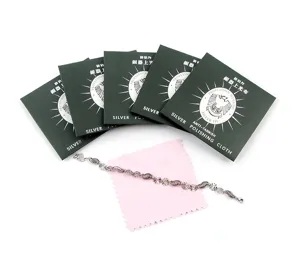 Silver polishing cloth detail view with green packaging and cleaning cloth for jewelry care.